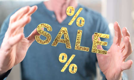 Sales and discounts concept between hands of a man in backgroundの写真素材