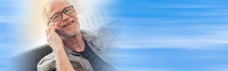 Portrait of smiling mature man talking on mobil phone, light effectの写真素材