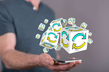 Update concept above a smartphone held by a man in background