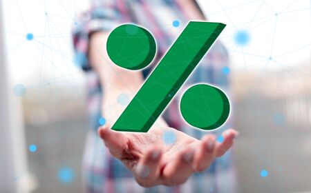 Percent concept above the hand of a woman in backgroundの写真素材