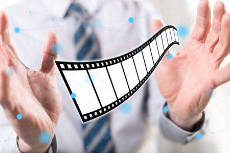 Movies, video and cinema concept between hands of a man in backgroundの写真素材