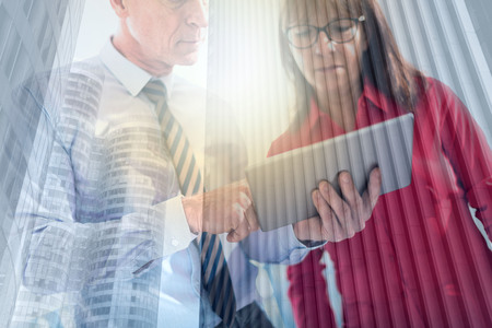 Business people using tablet in office, double exposure, light effectの写真素材
