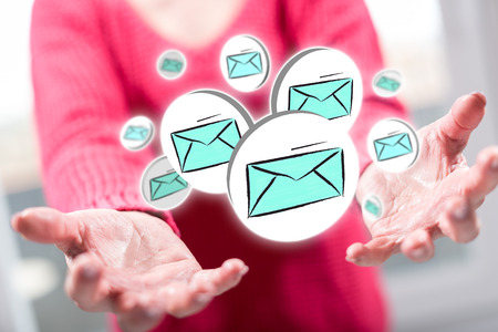 E-mail concept above the hands of a woman in backgroundの写真素材