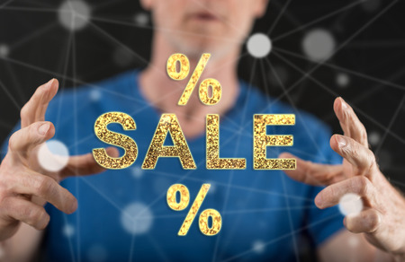 Sales and discounts concept between hands of a man in backgroundの写真素材