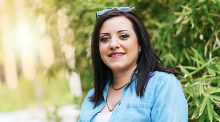 Portrait of happy pretty young brunette outdoors, light effectの写真素材