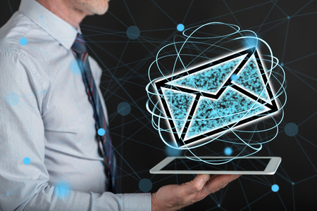 E-mail concept above a tablet held by a manの写真素材