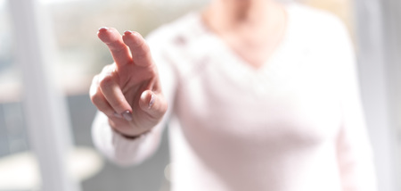 Woman touching a virtual screen with her fingers, selective focus