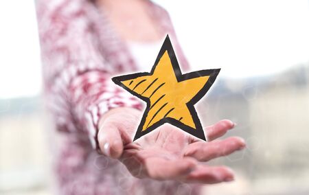 Favorite star concept above the hand of a woman in backgroundの写真素材