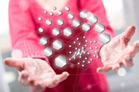 Abstract network concept above the hands of a woman in backgroundの写真素材