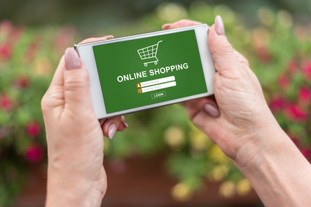 Female hands holding a smartphone with online shopping conceptの写真素材