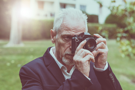 Mature man taking pictures outdoors, light effectの写真素材