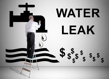 Man on a ladder drawing water leak concept on a wallの写真素材