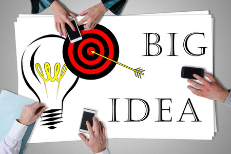 Big idea concept placed on a desk with hands using smartphonesの写真素材
