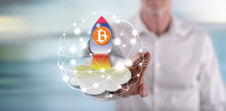Man touching a bitcoin rise concept on a touch screen with his fingerの写真素材
