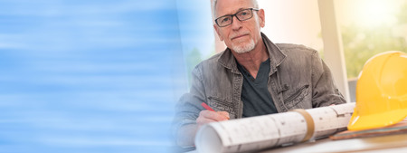 Portrait of architect working on plans at office, light effetの写真素材
