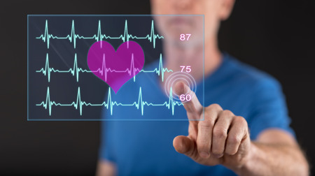 Man touching a heart beats graph concept on a touch screen with his fingerの写真素材