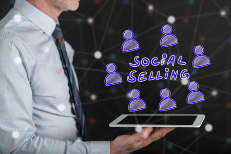 Social selling concept above a tablet held by a manの写真素材
