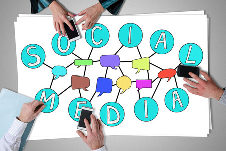 Social media concept placed on a desk with hands using smartphones