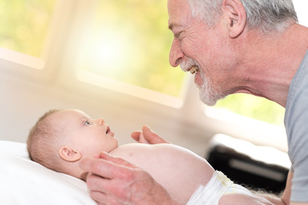 Happy grandfather holding the hands of his granddaughterの写真素材