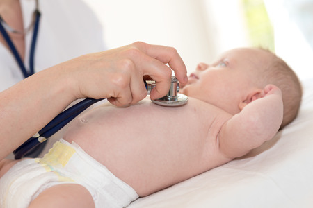 Hand of pediatrician using stethoscope to examine a little babyの写真素材