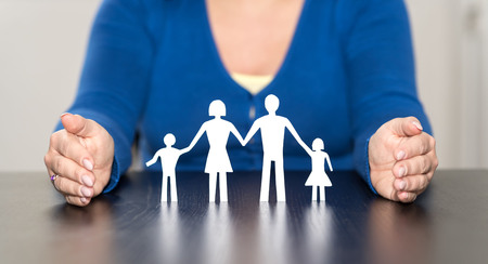 Insurer protecting family with his handsの写真素材