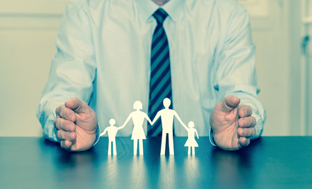 Insurer protecting family with his handsの写真素材
