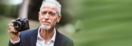 Mature man taking pictures outdoors