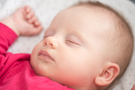 Portrait of cute baby girl sleeping in her crib, close upの写真素材