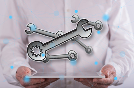 Maintenance service concept above a tablet held by a man in backgroundの写真素材