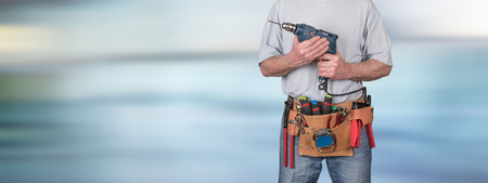 Building worker with tool belt on blurred backgroundの写真素材