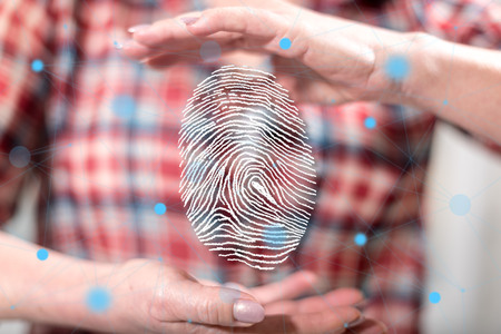 Fingerprint security system concept between hands of a woman in backgroundの写真素材