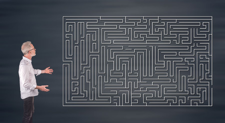 Businessman showing a labyrinth concept on a wall screenの写真素材