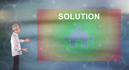 Businessman showing a solution concept on a wall screen