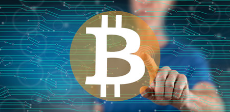 Man touching a bitcoin concept on a touch screen with his finger