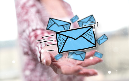E-mail concept above the hand of a woman in backgroundの写真素材