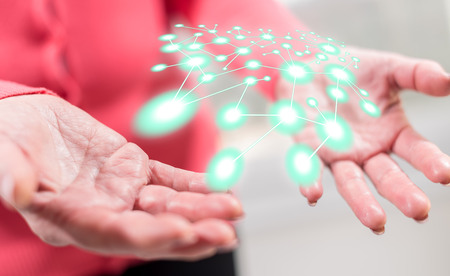 Network concept above the hands of a woman in backgroundの写真素材