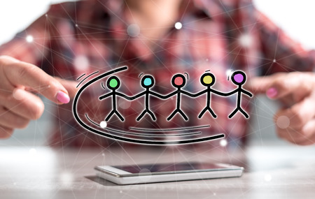 Smartphone with teamwork concept between hands of a woman in backgroundの写真素材