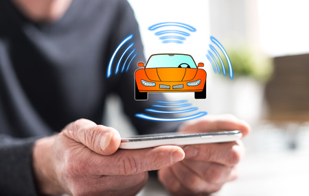 Hands of man holding a smartphone with smart car concept