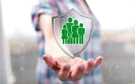 Family protection concept above the hand of a woman in backgroundの写真素材