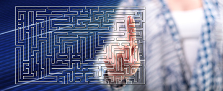 Woman touching a labyrinth concept on a touch screen with her fingerの写真素材