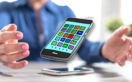 Smartphone with apps concept between hands of a woman in backgroundの写真素材