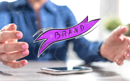 Smartphone with brand concept between hands of a woman in backgroundの写真素材