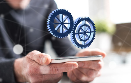 Hands of man holding a smartphone with teamwork conceptの写真素材