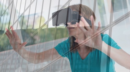 Mature woman using a virtual reality headset, double exposure