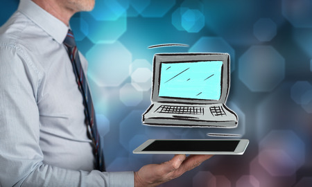 Computer concept above a tablet held by a manの写真素材