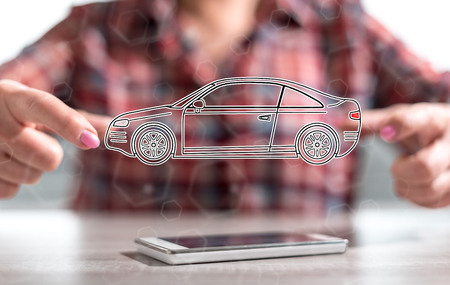 Smartphone with car transport concept between hands of a woman in backgroundの写真素材
