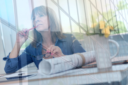 Architect working on plans at office, light effect, double exposureの写真素材