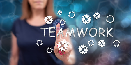 Woman touching a teamwork concept on a touch screen with her fingerの写真素材