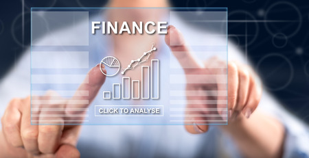 Woman touching a finance concept on a touch screen with her fingersの写真素材