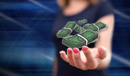 Money concept above the hand of a woman in backgroundの写真素材